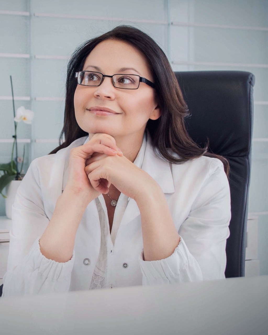 Dr. med. Natalie Wiesen im weißen Kittel am Schreibtisch ihrer Praxis in Hillesheim