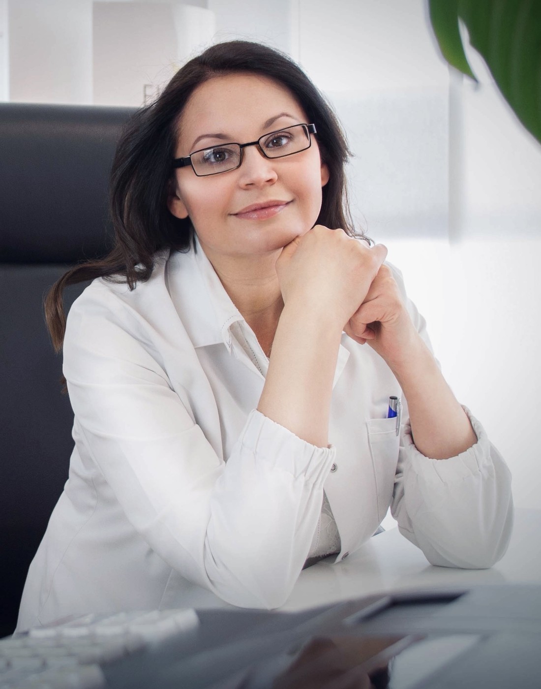 Dr. med. Natalie Wiesen im Arztkittel am Schreibtisch ihrer Praxis in Hillesheim